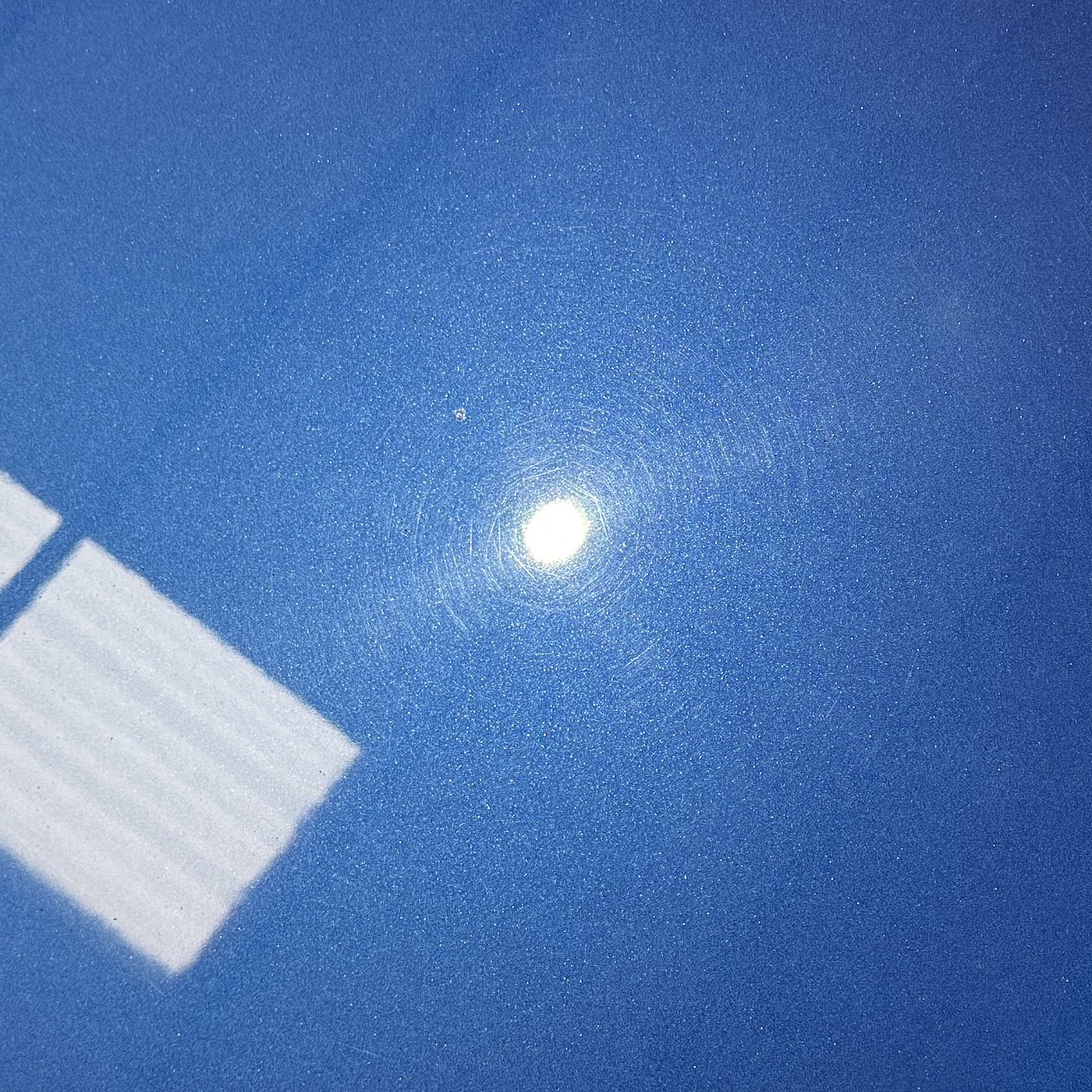Audi R8 quarter panel before polishing, concentric swirl marks ringing the light